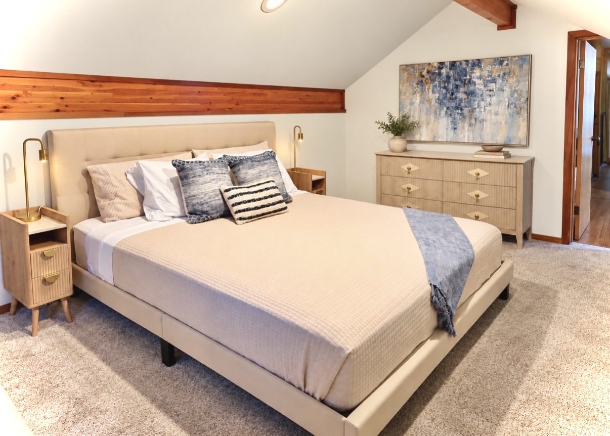 Blue king bedroom with natural wood trim and artwork